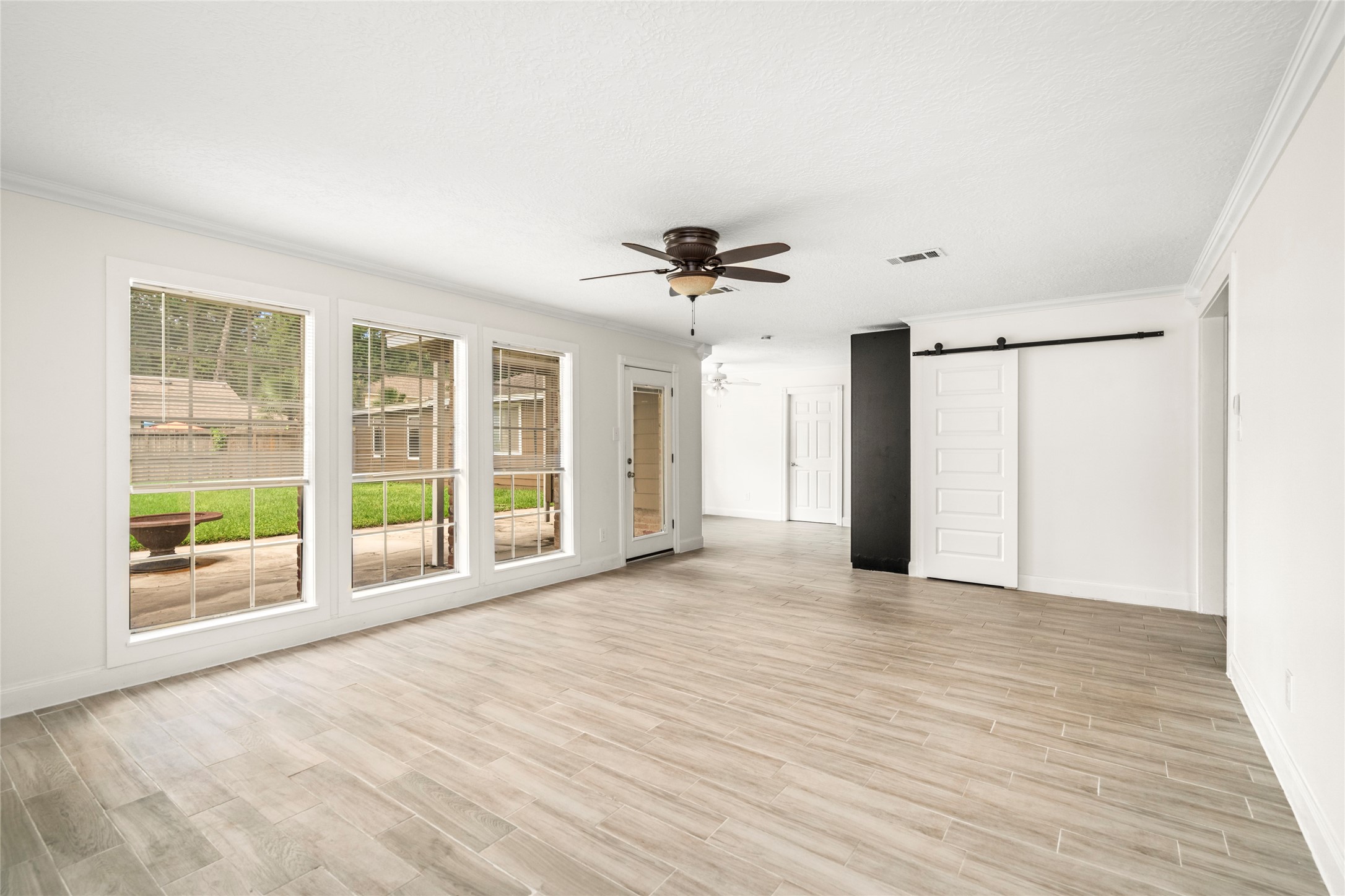 560 Landfall Lane Conroe, TX 77302 - Photo 16 of 41 Secondary view of the family room looking into the breakfast room. Extra storage space is located behind the barn door.