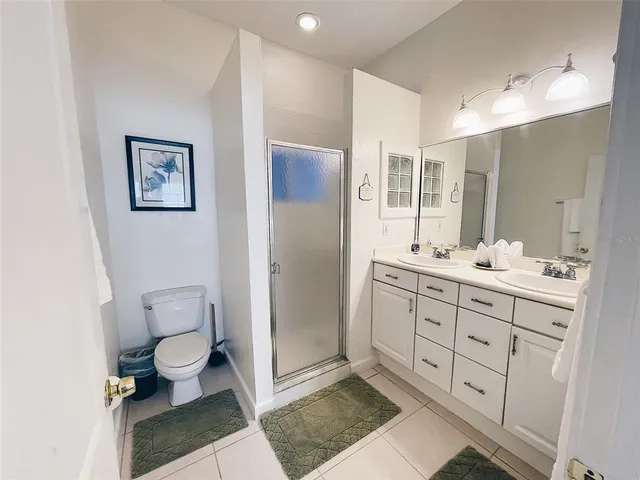 a bathroom with a double vanity sink mirror and toilet