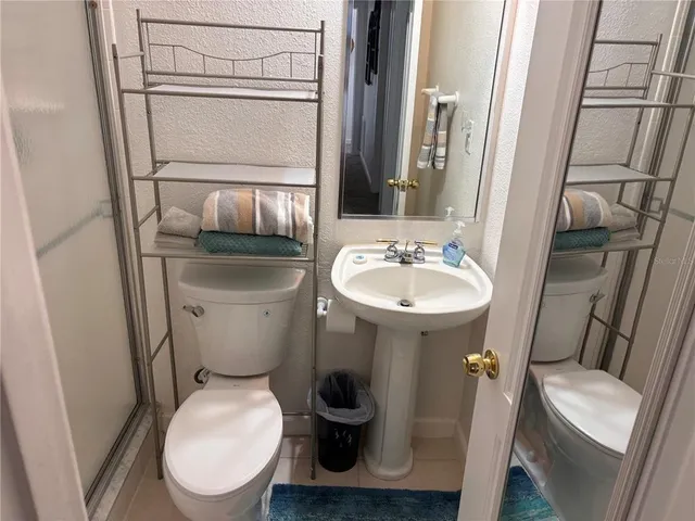 a bathroom with a toilet a sink and a mirror