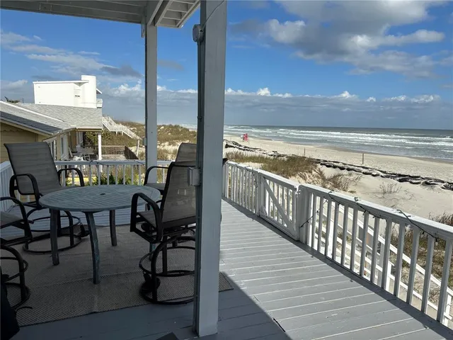 a view of a balcony with chairs and wooden floor