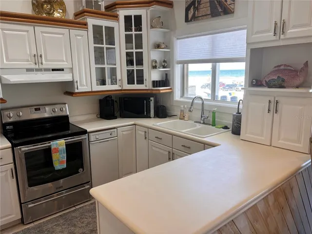 a kitchen with stainless steel appliances a stove a sink and a microwave