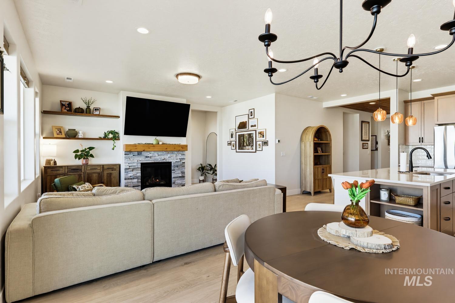 5990 West Ladle Rpds Street Meridian, ID 83646 - Photo 21 of 42 Open-concept living space featuring wood-finish flooring, a stone-clad fireplace with a wood mantle, and recessed lighting