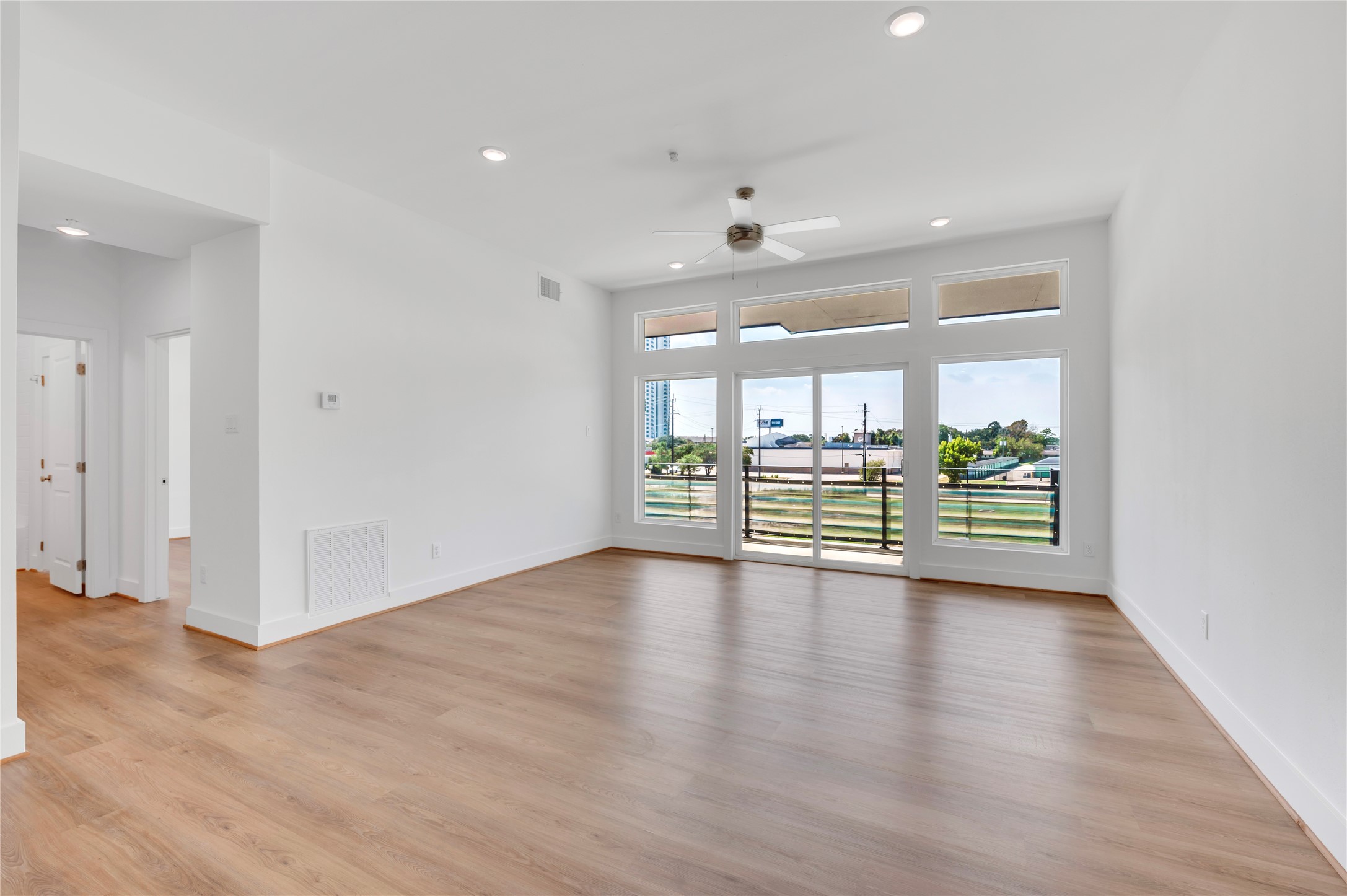 119 Kirby Road, Unit 5205 Seabrook, TX 77586 - Photo 32 of 46 Spacious living area with large windows offering abundant natural light and views, featuring elegant wood flooring and a modern ceiling fan.