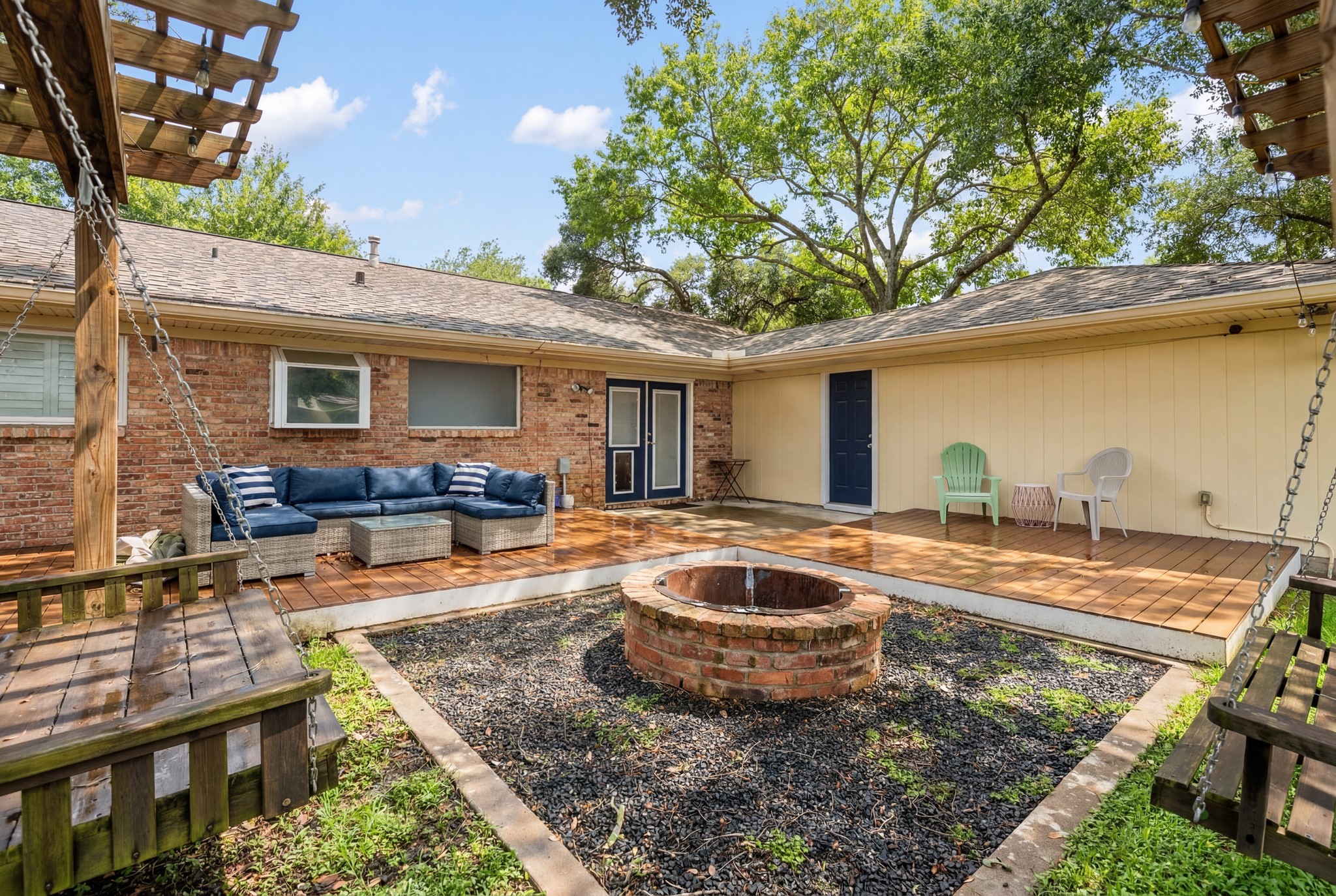 5658 Cartagena Street Houston, TX 77035 - Photo 22 of 33 The backyard boasts 2 spacious wooden decks ideal for gatherings, anchored by a brick fire pit and 2 pergola swings.