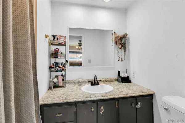 a bathroom with a granite countertop sink and a mirror