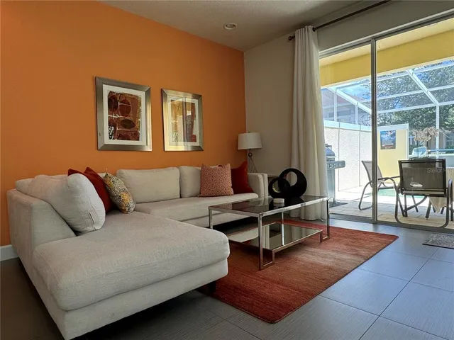 a living room with furniture a lamp next to a window