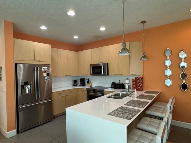 a kitchen with stainless steel appliances a refrigerator sink and microwave