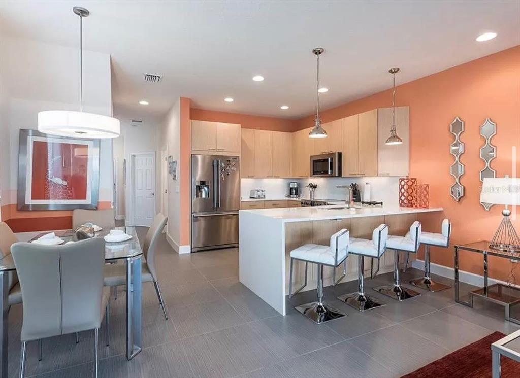 1641 Retreat Circle Clermont, FL 34714 - Photo 4 of 16 a kitchen with a dining table chairs refrigerator and microwave