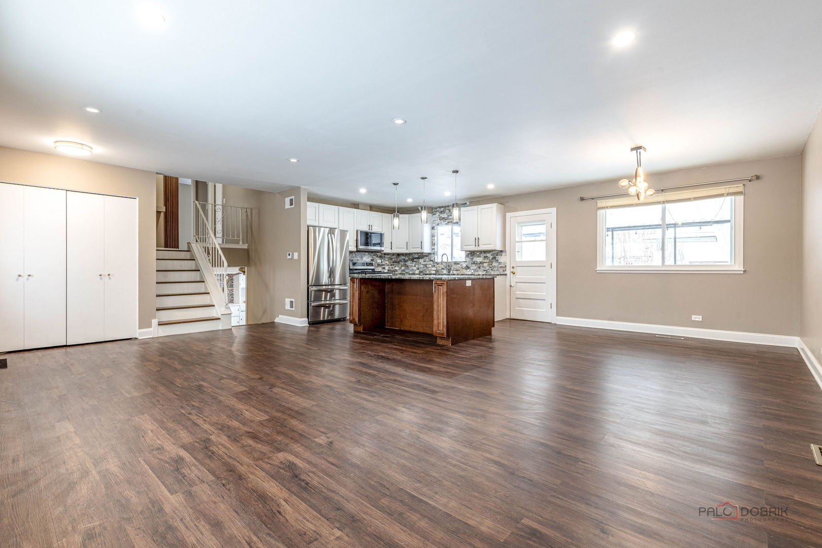 681 South Mt Prospect Road Des Plaines, IL 60016 - Photo 3 of 20 an empty room with wooden floor and a kitchen