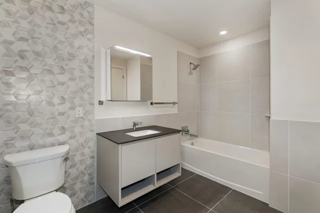 a bathroom with a sink toilet vanity and shower