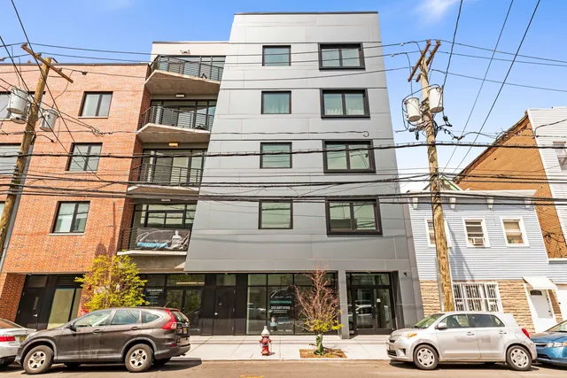 a front view of a residential apartment building with a parking space