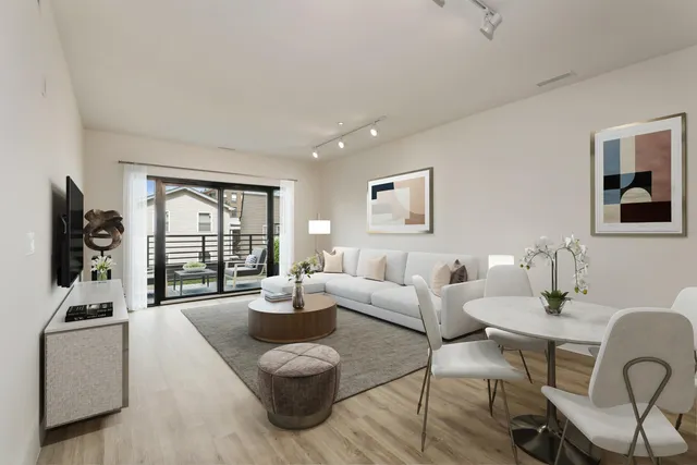 a living room with furniture a large window and dining table