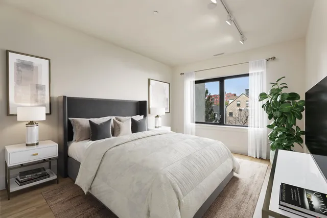 a bedroom with a large bed and a potted plant