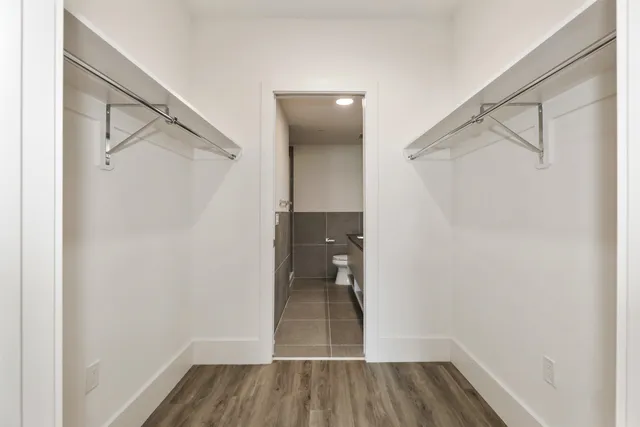 a view of walk in closet with wooden floor