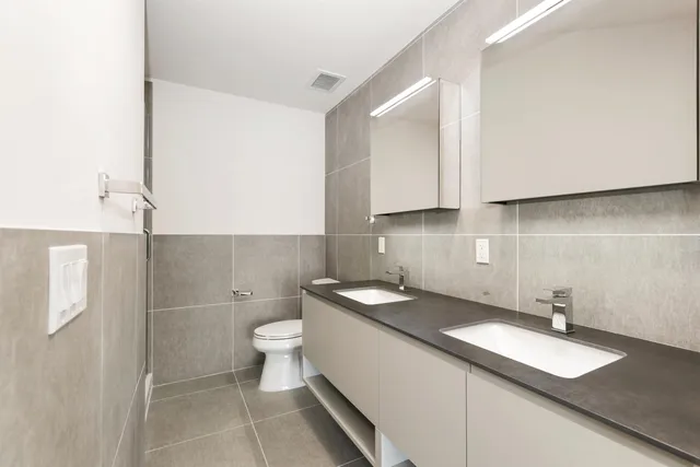 a bathroom with a granite countertop sink a toilet and a mirror