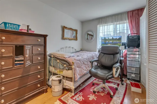 a bedroom with a bed and wooden floor