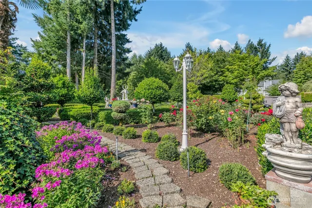 a view of a garden with flowers and brick walls