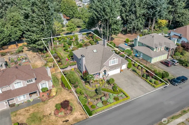 an aerial view of residential houses with outdoor space and trees