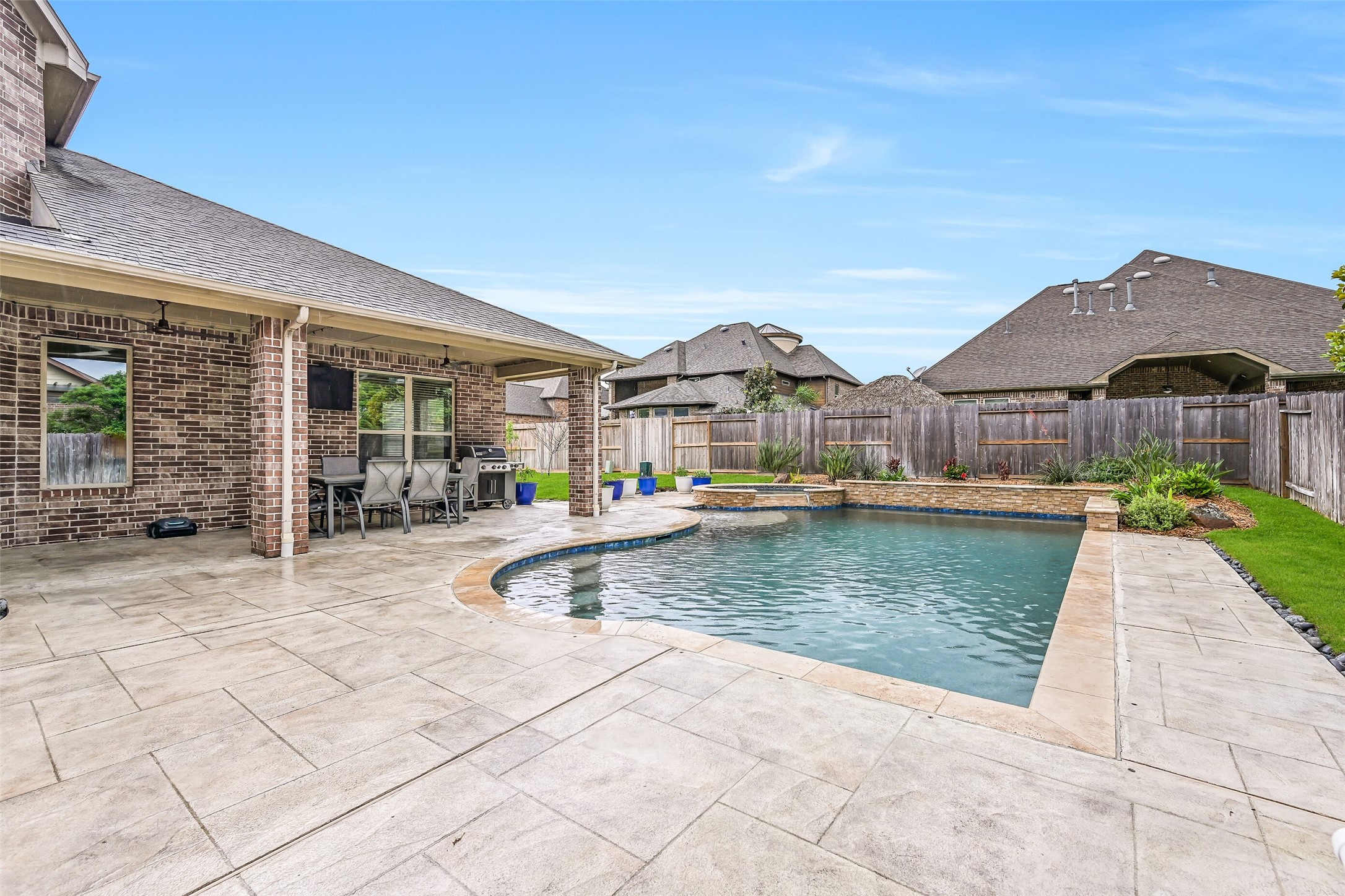1008 Point Isabel Lane Friendswood, TX 77546 - Photo 47 of 50 Expansive decking surrounds the pool, offering plenty of space for lounging and gatherings. A Catch-A-Kid safety net is in place, providing an added layer of protection while maintaining visibility of the pool area.