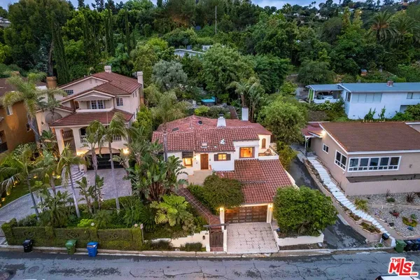 a aerial view of a house with table and chairs under an umbrella