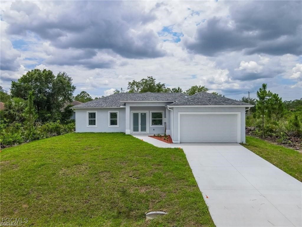 744 Clancy Street East Lehigh Acres, FL 33974 - Photo 1 of 14 a front view of a house with garden
