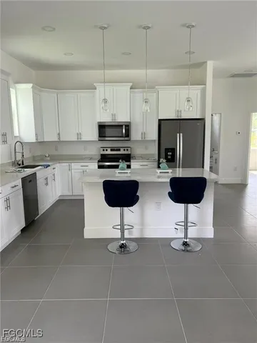 a kitchen with stainless steel appliances a stove a sink a stove a refrigerator cabinets and dining table