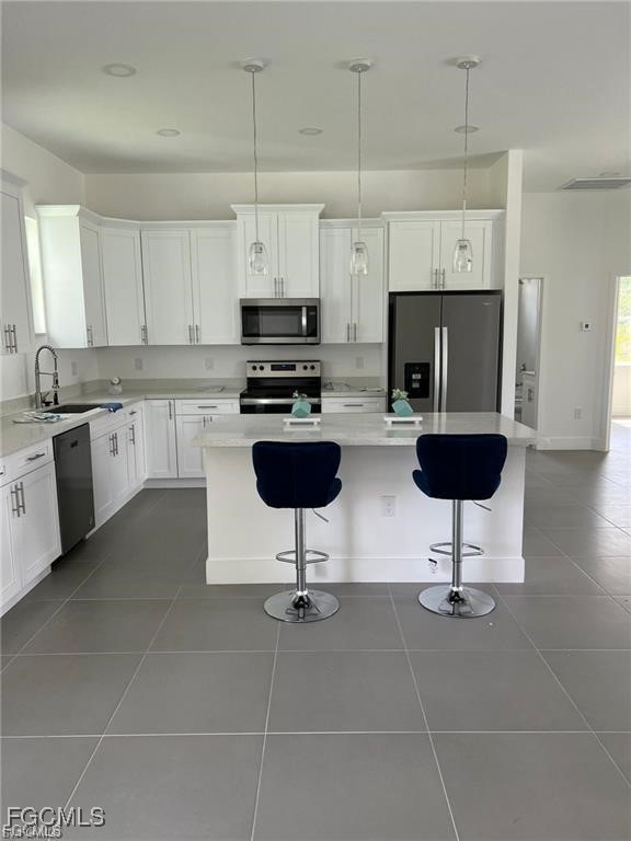 744 Clancy Street East Lehigh Acres, FL 33974 - Photo 3 of 14 a kitchen with stainless steel appliances a stove a sink a stove a refrigerator cabinets and dining table