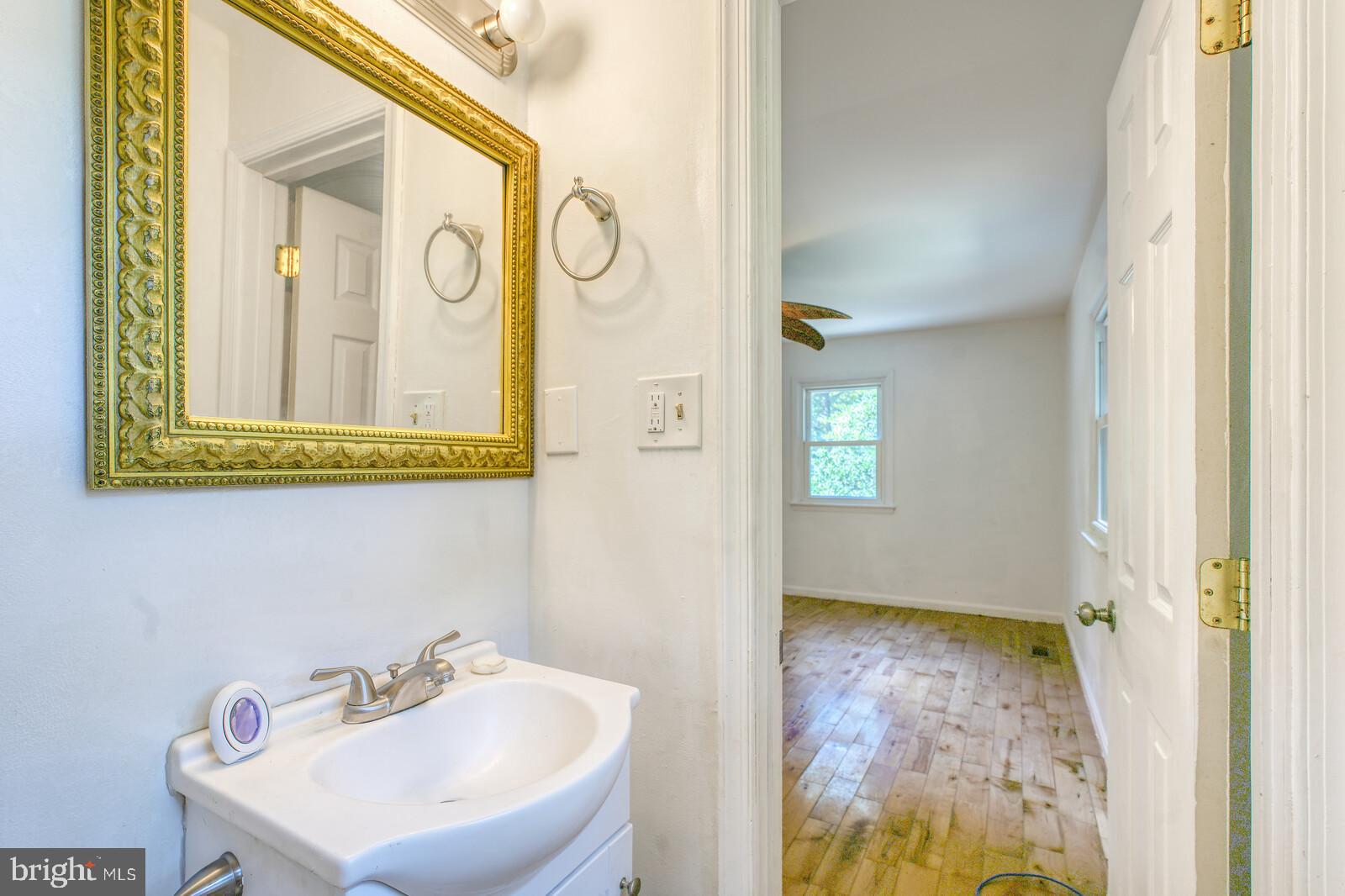 1142 Calvert Beach Road St. Leonard, MD 20685 - Photo 31 of 63 a bathroom with a sink and a mirror
