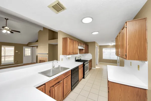 a large kitchen with kitchen island a sink stainless steel appliances and cabinets
