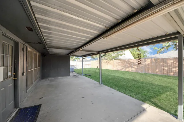 a view of a backyard with floor to ceiling window and tree