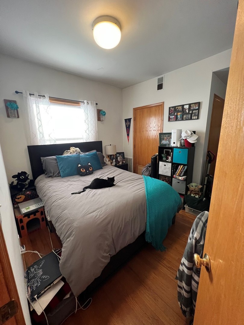 628 West Patterson Avenue, Unit 3S Chicago, IL 60613 - Photo 8 of 10 a bedroom with a bed and wooden floor