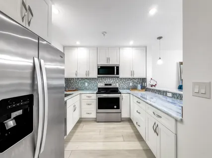 a large kitchen with a refrigerator stove and microwave