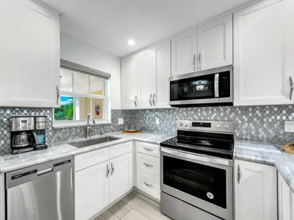 a kitchen with cabinets stainless steel appliances a sink stove and microwave