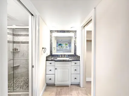 a bathroom with a granite countertop sink a vanity and a shower