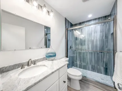 a bathroom with a granite countertop sink toilet and shower