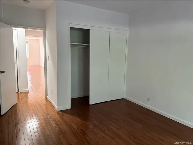 an empty room with wooden floor and closet