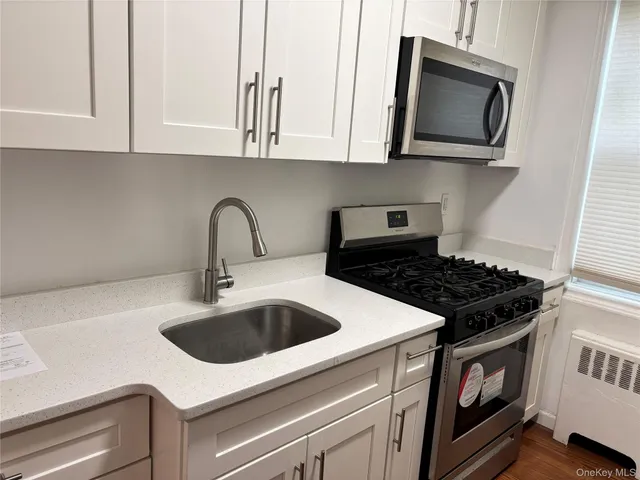 a kitchen with stainless steel appliances granite countertop a sink stove and microwave