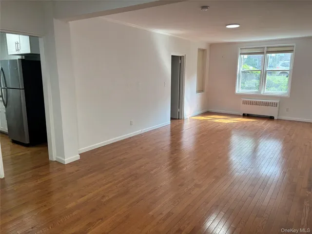 an empty room with wooden floor and a window
