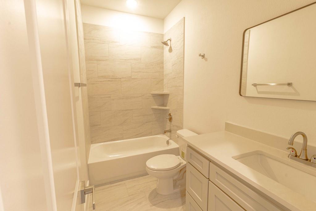 536 Highview Court Godley, TX 76044 - Photo 20 of 27 a bathroom with a granite countertop sink toilet a shower and a mirror