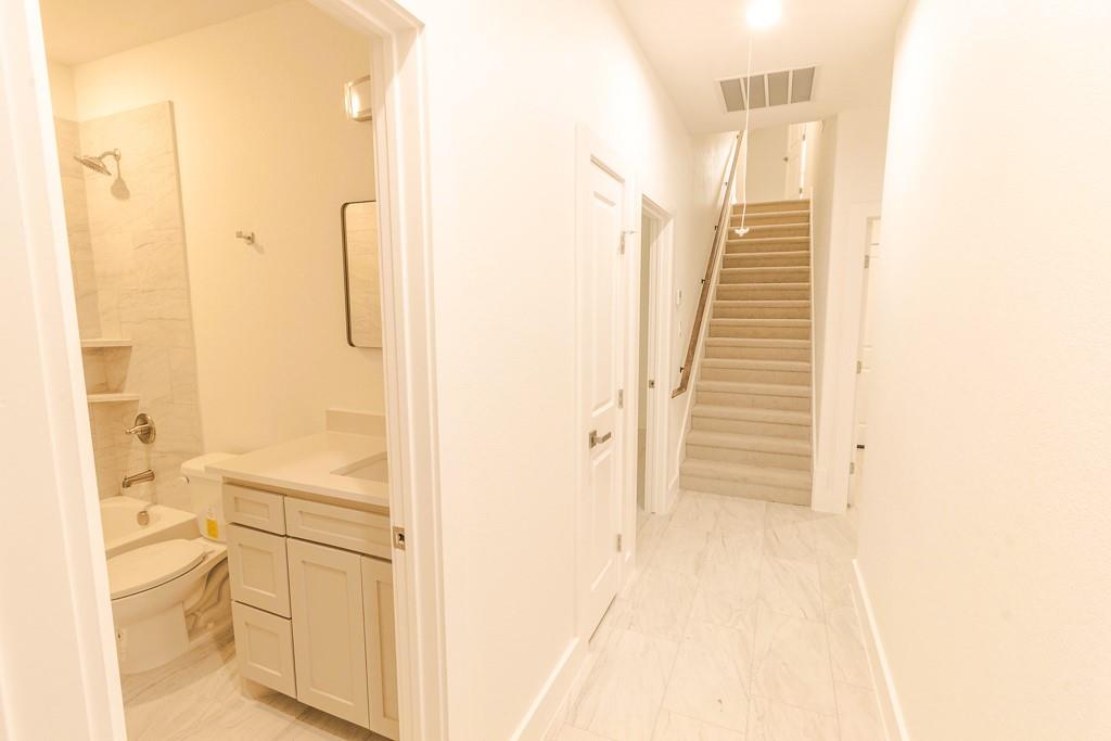 536 Highview Court Godley, TX 76044 - Photo 21 of 27 a bathroom with a granite countertop sink a toilet and a shower