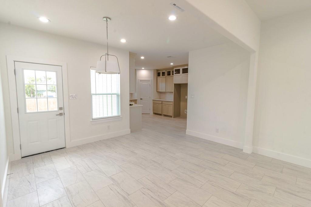 536 Highview Court Godley, TX 76044 - Photo 4 of 27 an empty room with windows and refrigerator