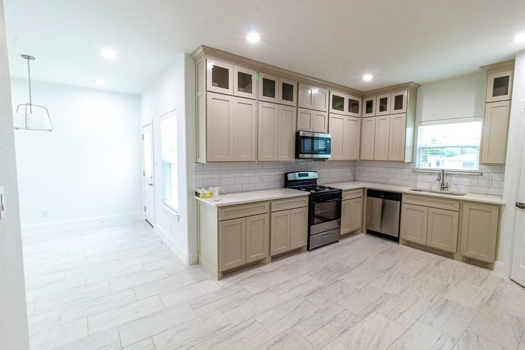 536 Highview Court Godley, TX 76044 - Photo 9 of 27 a kitchen with stainless steel appliances granite countertop a stove a sink and a refrigerator