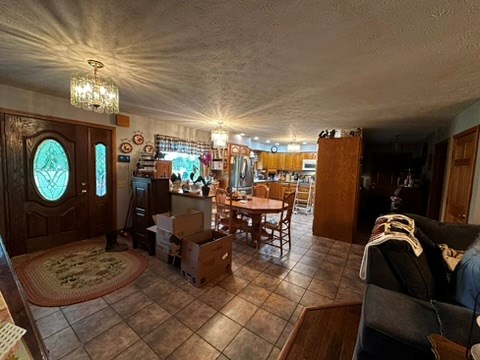 10716 County Line Road Greenville, PA 16125 - Photo 14 of 43 a view of a dining room and livingroom with furniture a rug a fireplace and a chandelier