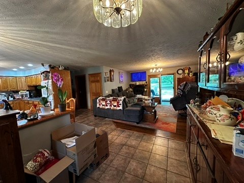 10716 County Line Road Greenville, PA 16125 - Photo 9 of 43 a living room with furniture a fireplace and a chandelier