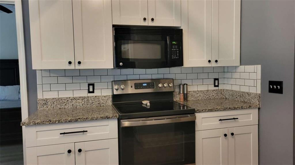 2140 Summerset Drive Monroe, GA 30656 - Photo 12 of 43 a kitchen with granite countertop white cabinets and black stainless steel appliances