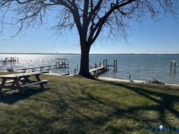 a view of a backyard with lawn chairs under an umbrella