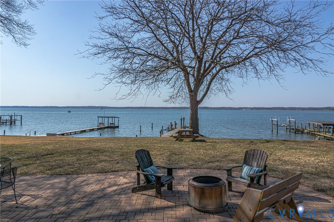 1159 Riverdale Road Warsaw, VA 22572 - Photo 39 of 42 a view of a patio with lawn chairs under an umbrella