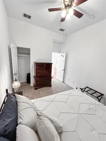 a bedroom with a bed and ceiling fan