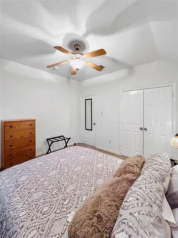 a bedroom with a large bed and a chandelier
