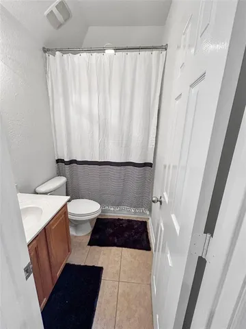 a bathroom with a sink a toilet a window and shower